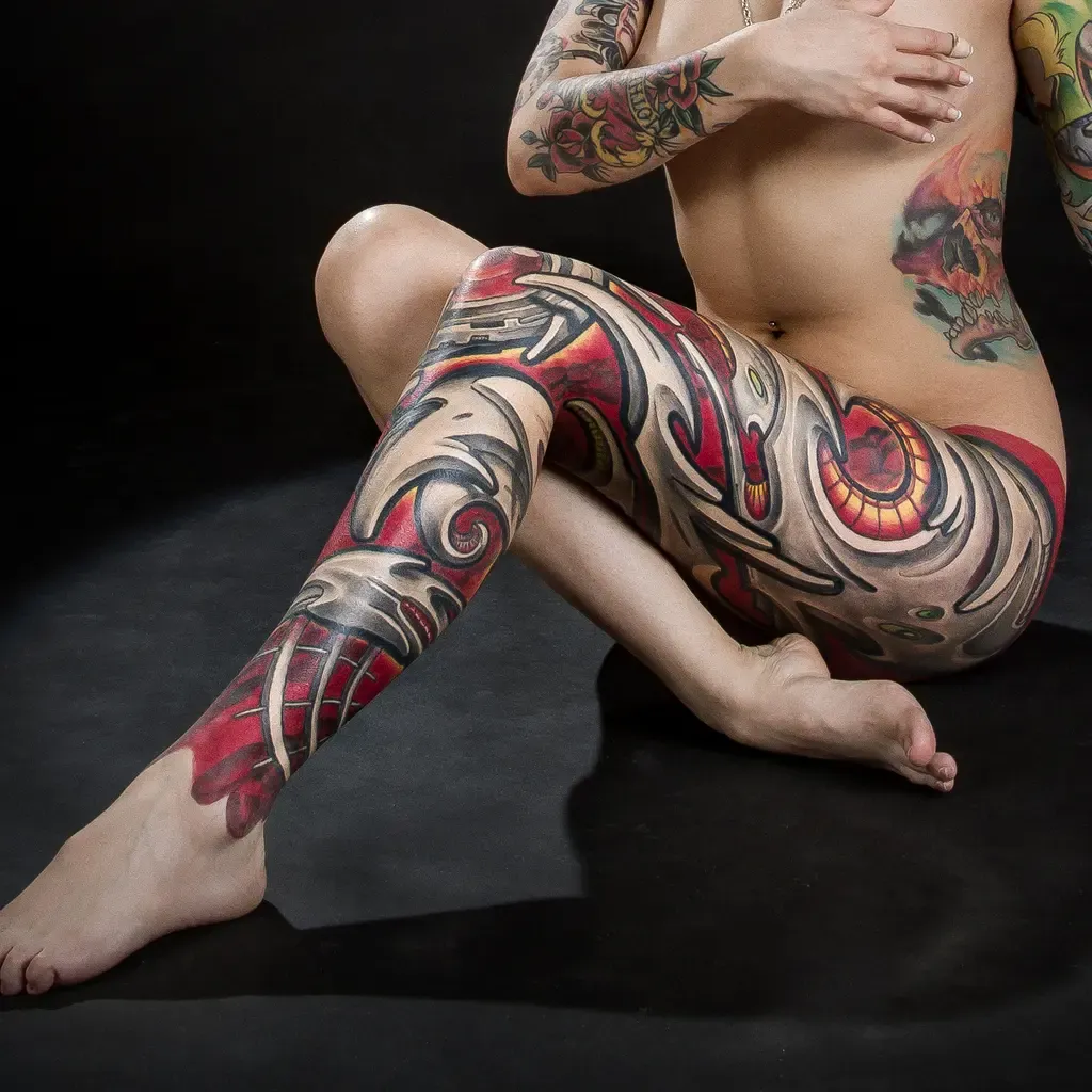 Biomechanical tattoo of a woman with a robotic leg by Javier Obregón.